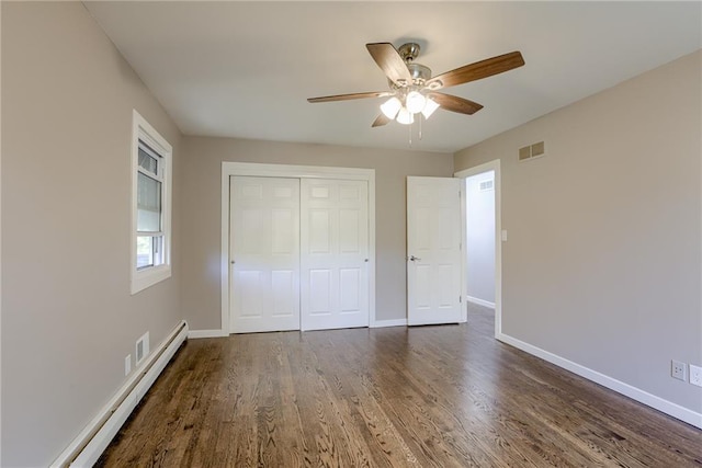 unfurnished bedroom with a baseboard radiator, visible vents, baseboards, and wood finished floors