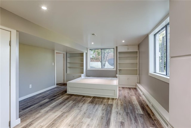 unfurnished bedroom with visible vents, baseboards, wood finished floors, and recessed lighting