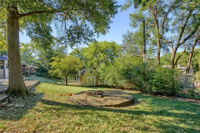 view of yard featuring an outdoor fire pit, a shed, and an outbuilding