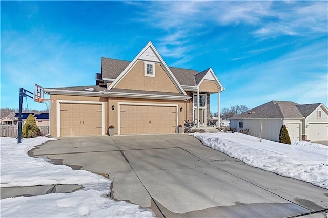 view of front of home with a garage, concrete driveway, and stucco siding