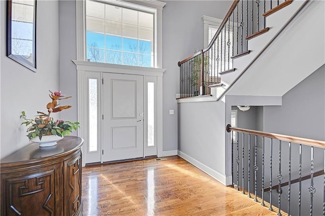 entrance foyer with a high ceiling, wood finished floors, and baseboards