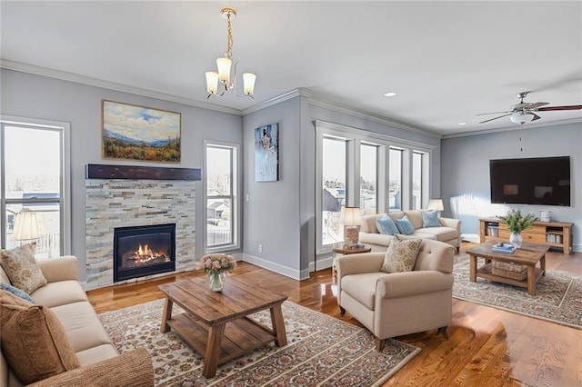 living room with baseboards, a fireplace, wood finished floors, and crown molding