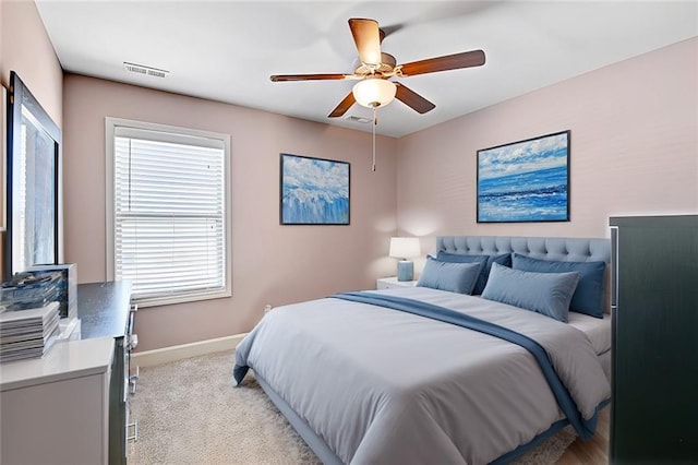 bedroom featuring light carpet, ceiling fan, visible vents, and baseboards