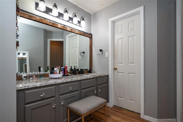 bathroom with vanity, baseboards, and wood finished floors