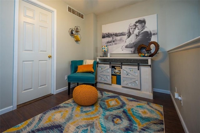 sitting room featuring wood finished floors, visible vents, and baseboards