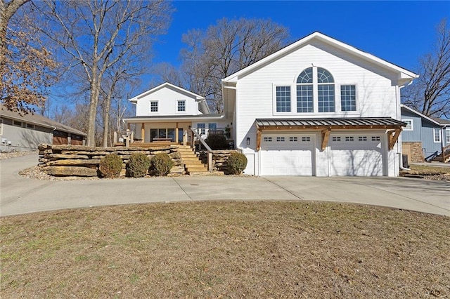 view of front of home featuring concrete driveway, metal roof, an attached garage, a standing seam roof, and stairs