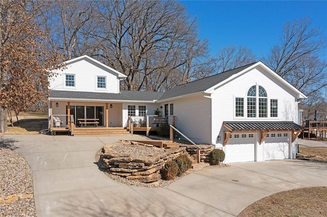 traditional-style home with driveway, a standing seam roof, an attached garage, and metal roof