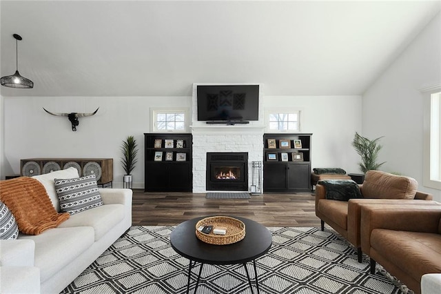 living room with lofted ceiling, plenty of natural light, a fireplace, and wood finished floors