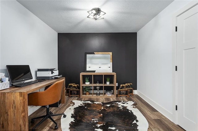 home office with a textured ceiling, baseboards, and wood finished floors