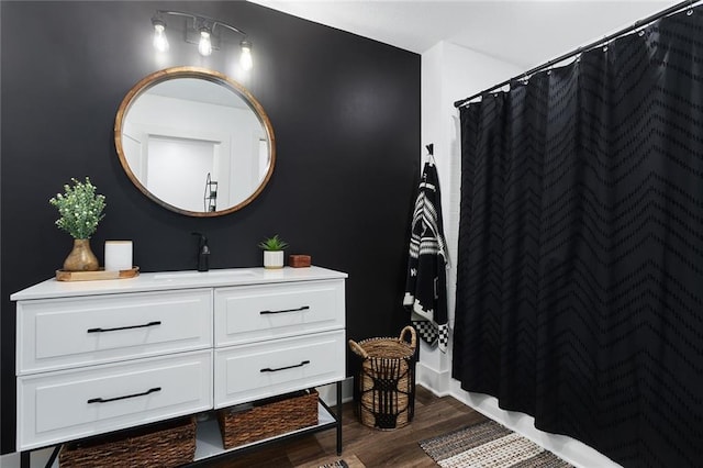 full bathroom with a shower with shower curtain, wood finished floors, and vanity