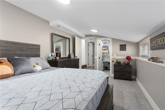 carpeted bedroom with lofted ceiling and baseboards