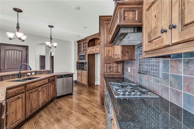 kitchen featuring tasteful backsplash, appliances with stainless steel finishes, a sink, and wood finished floors