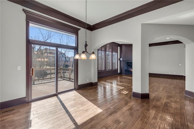 unfurnished dining area with wood finished floors, visible vents, and baseboards