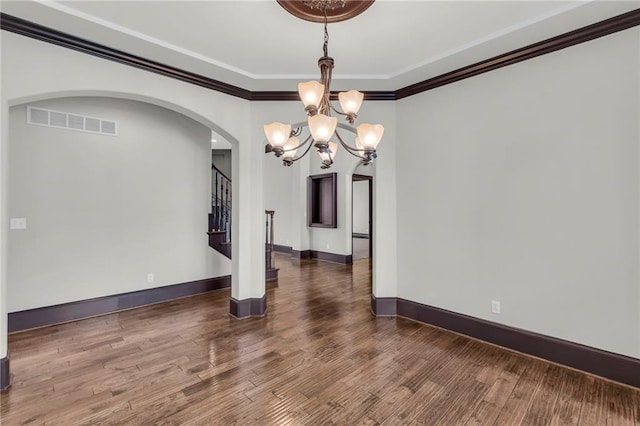 spare room with baseboards, visible vents, ornamental molding, wood finished floors, and stairs