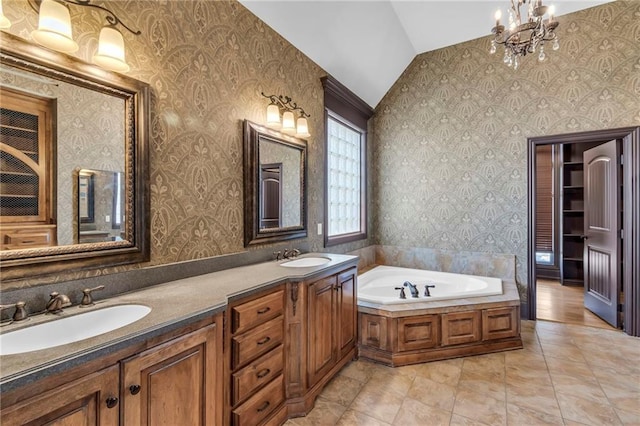 full bath with double vanity, wallpapered walls, a sink, vaulted ceiling, and a bath