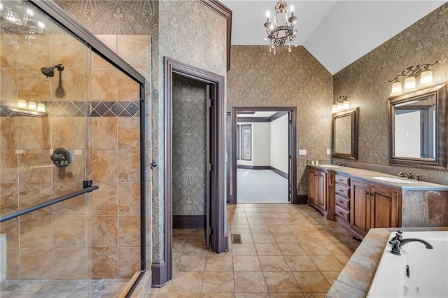 bathroom featuring lofted ceiling, a shower stall, a sink, and wallpapered walls