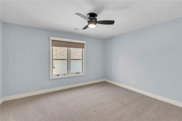 unfurnished room with carpet floors, visible vents, baseboards, and a ceiling fan