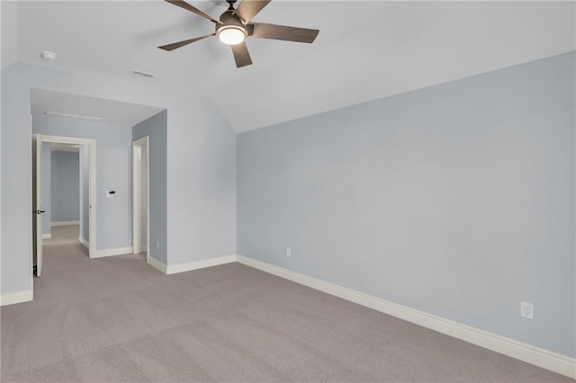 interior space with carpet floors, a ceiling fan, visible vents, vaulted ceiling, and baseboards