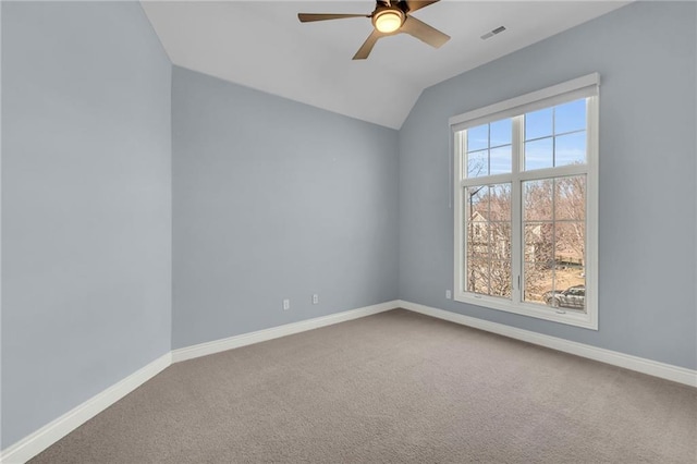 carpeted empty room featuring a ceiling fan, lofted ceiling, visible vents, and baseboards