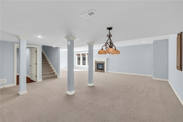 basement featuring stairway, a glass covered fireplace, visible vents, and baseboards