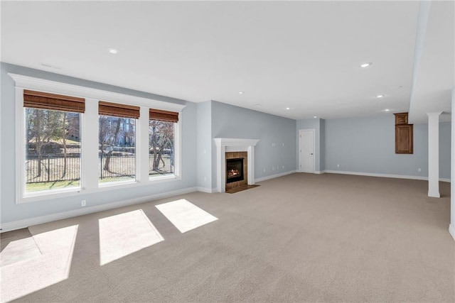 unfurnished living room with recessed lighting, baseboards, light carpet, and a tiled fireplace