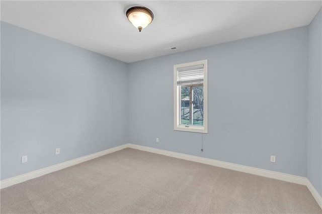 spare room with carpet, visible vents, and baseboards