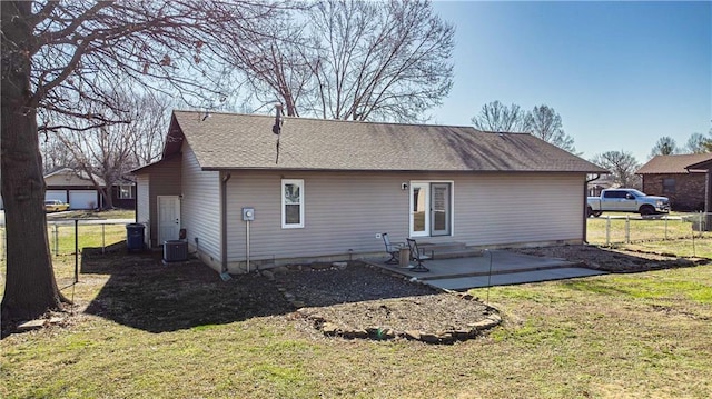 back of house with entry steps, a yard, fence, and central AC