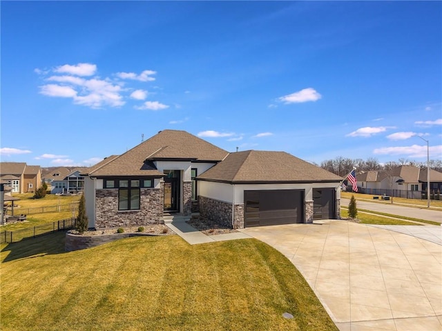 prairie-style house with a front yard, fence, driveway, stone siding, and a garage