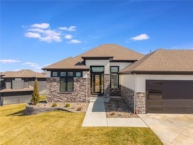 prairie-style home with driveway, an attached garage, a shingled roof, stucco siding, and a front lawn