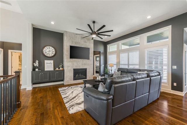 4510 NW 70th Ter, Kansas City, MO 64151 - living room featuring dark wood finished floors, a ceiling fan, baseboards, and a large fireplace