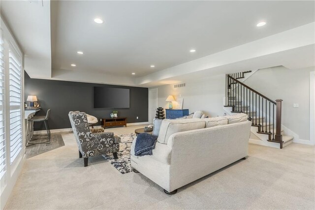 4510 NW 70th Ter, Kansas City, MO 64151 - carpeted living room with stairway, visible vents, baseboards, recessed lighting, and a raised ceiling