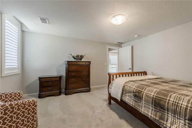 4510 NW 70th Ter, Kansas City, MO 64151 - bedroom with visible vents, light carpet, a textured ceiling, and baseboards
