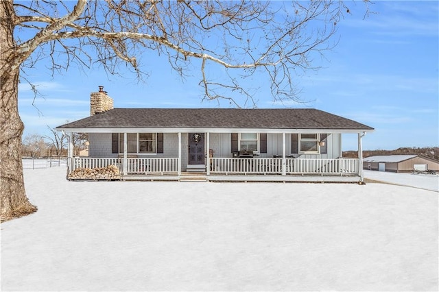 single story home with covered porch, roof with shingles, a chimney, and board and batten siding