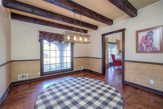 unfurnished dining area featuring wainscoting, visible vents, beamed ceiling, and dark wood-style flooring