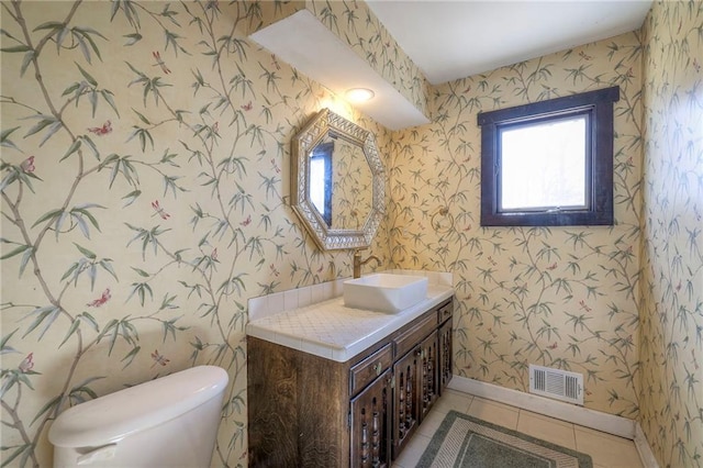 half bath featuring tile patterned flooring, visible vents, toilet, and wallpapered walls