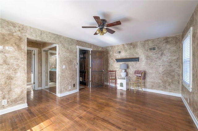 unfurnished living room with a ceiling fan, visible vents, baseboards, and wood finished floors