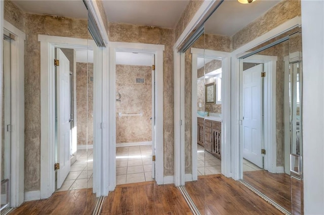 corridor featuring baseboards and wood finished floors