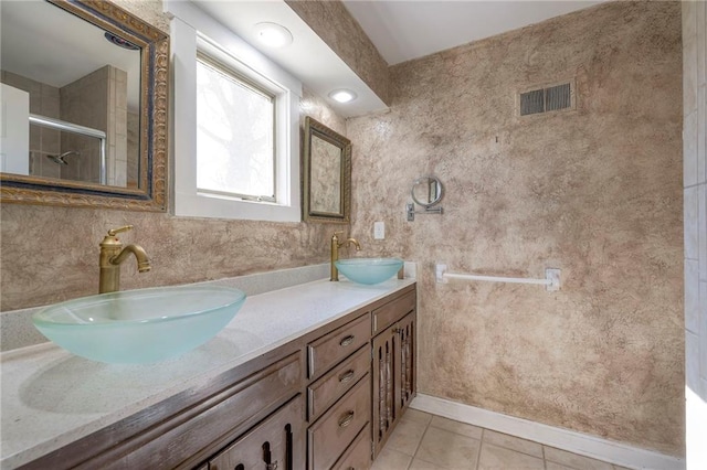 full bath with a stall shower, tile patterned flooring, a sink, and visible vents