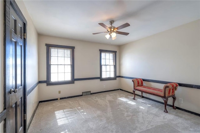 unfurnished room featuring carpet, visible vents, ceiling fan, and baseboards