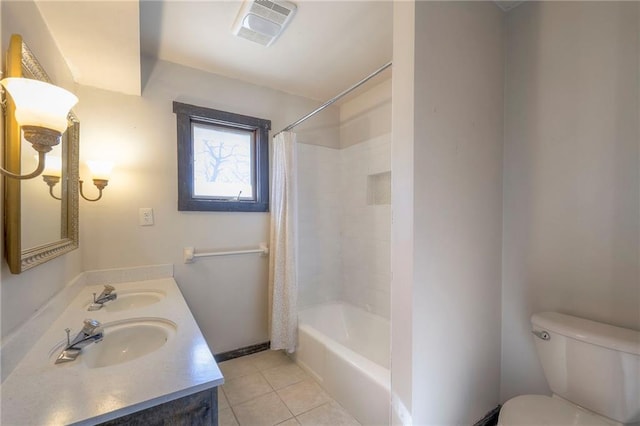 bathroom featuring toilet, a sink, visible vents, and tile patterned floors