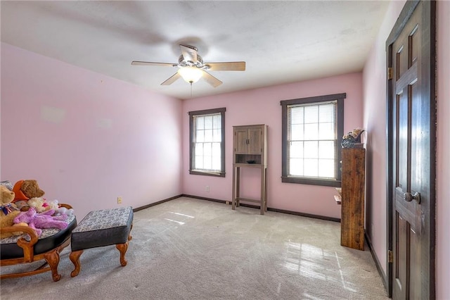 bedroom with light colored carpet, ceiling fan, and baseboards