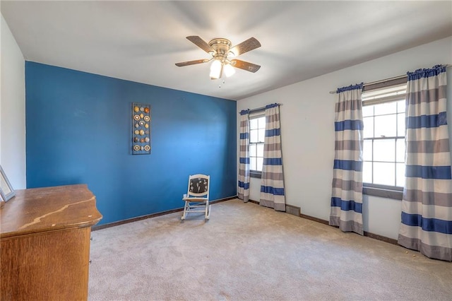 misc room with carpet, a ceiling fan, and baseboards