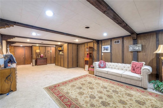 carpeted living area with wood walls, beamed ceiling, visible vents, and recessed lighting