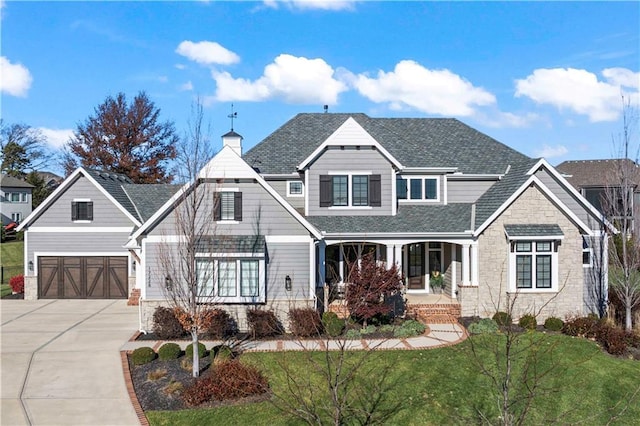 craftsman inspired home featuring driveway, a garage, a shingled roof, a porch, and a front yard