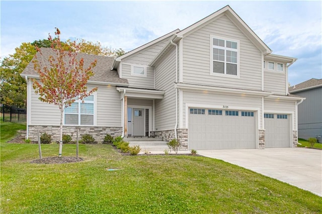 craftsman-style home featuring concrete driveway, a front lawn, an attached garage, and stone siding