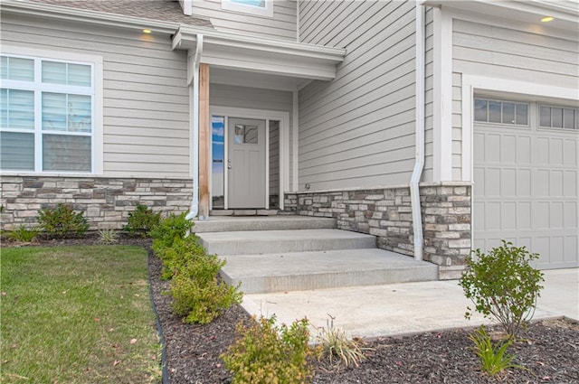 view of exterior entry featuring a garage and stone siding