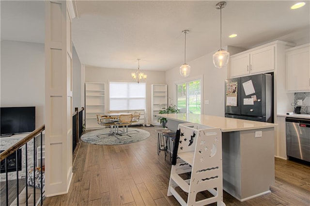 kitchen featuring wood finished floors, white cabinets, dishwasher, and freestanding refrigerator