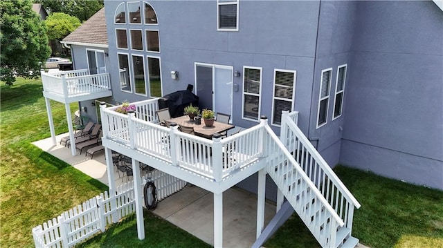 back of property featuring a patio area, a lawn, stairway, and a wooden deck