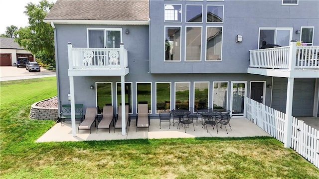 back of property featuring a shingled roof, fence, a yard, a patio area, and stucco siding