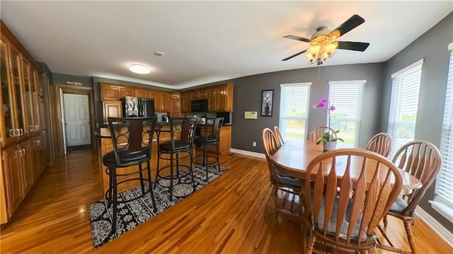 dining space with plenty of natural light, baseboards, ceiling fan, and wood finished floors